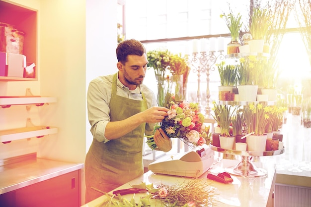 persone, affari, vendita e concetto di floristica - florista uomo che fa un bouquet in un negozio di fiori