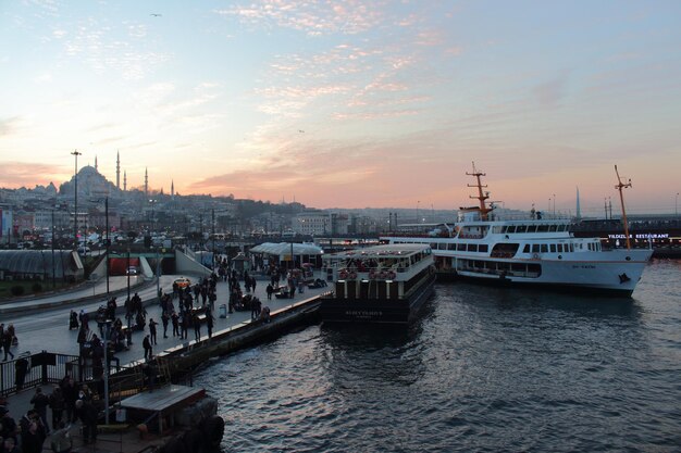 Persone al porto contro il cielo durante il tramonto