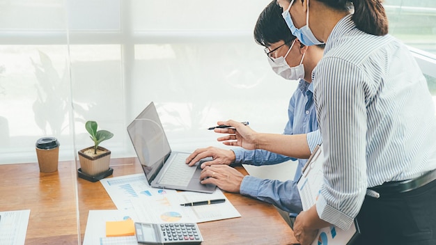 Persone asiatiche Lavoro di squadra di successo Business indossando maschera medica e di lavoro. Lavoro da un ufficio privato Distanziamento sociale nella situazione dell'epidemia di coronavirus