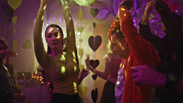 Persone attive che muovono la pista da ballo sotto le luci della discoteca festa di coppia energica