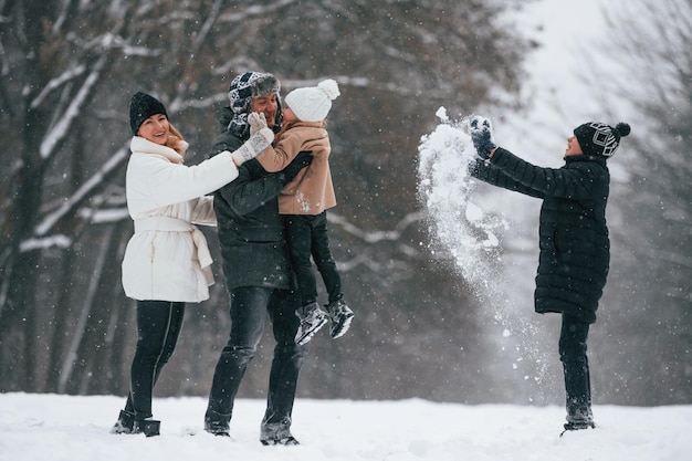 Persone attive Famiglia felice è all'aperto a godersi la neve in inverno insieme