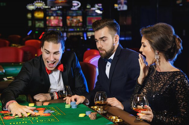 Persone belle e ricche che giocano alla roulette nel casinò