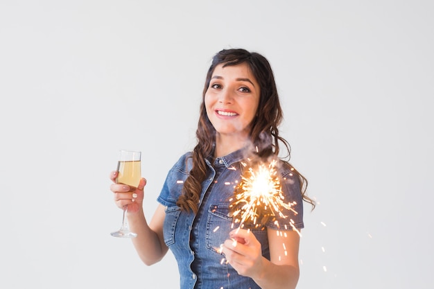 Persone, celebrazione e concetto di vacanza - Bella donna con sparkler e bicchiere di champagne su sfondo bianco con spazio di copia.