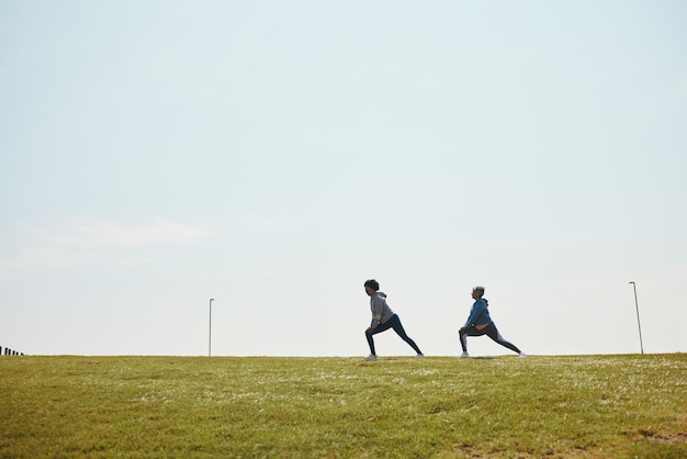 Persone che allungano il fitness e iniziano a correre flessibilità all'aperto e allenamento per la maratona con spazio mockup Squadra di corridori nel parco esercizio e corsa riscaldamento sport e salute e benessere dell'atleta