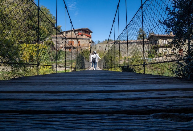 Persone che attraversano il ponte sospeso di Rupit