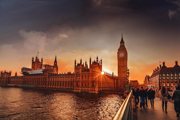 Persone che camminano sul ponte contro il Big Ben in città durante il tramonto