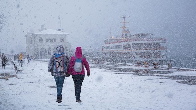 Persone che camminano sulla strada innevata