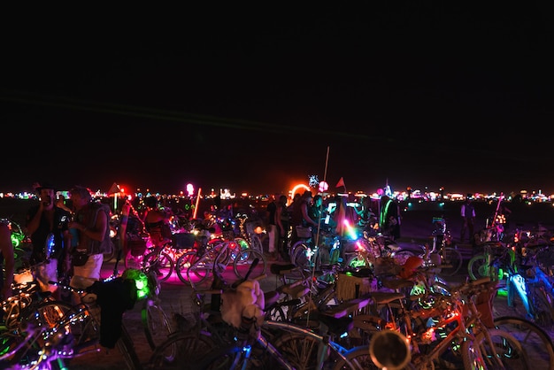 Persone che camminano verso il tramonto in un festival nel deserto