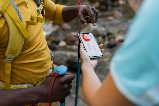 persone che fanno trekking in montagna che guardano la mappa sullo smartphone