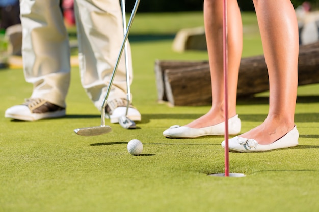 Persone che giocano a golf in miniatura all&#39;aperto