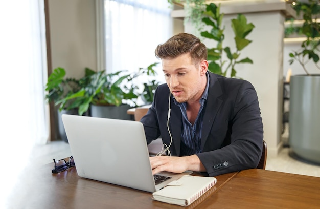 Persone che lavorano alle startup Due uomini d'affari che sorridono e fanno brainstorming mentre utilizzano laptopxA