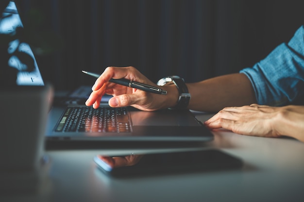 Persone che lavorano in ufficio di notte utilizzando laptop, notebook o computer. Affari o lavoro da casa concetto.