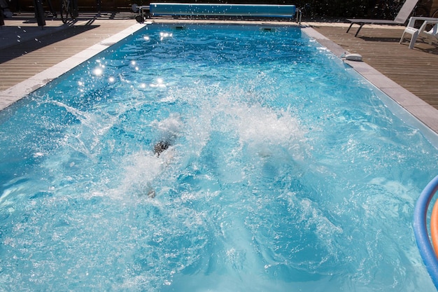 Persone che nuotano sott'acqua in una piscina blu