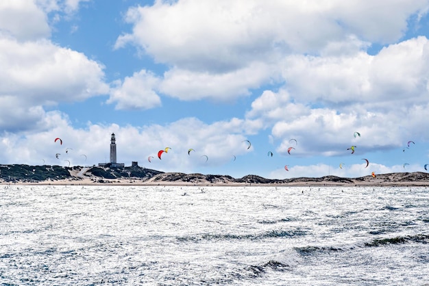 Persone che praticano il kitesurf sulla spiaggia di Los Caños de Meca, accanto al faro di Trafalgar.