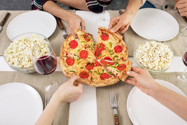 Persone che prendono fette di pizza