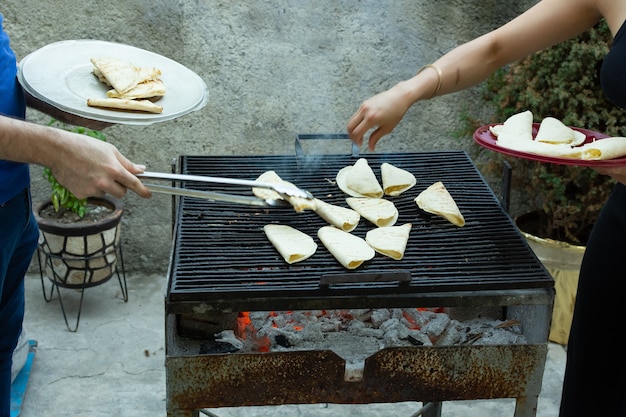 Persone che preparano quesadillas su una griglia a carbone