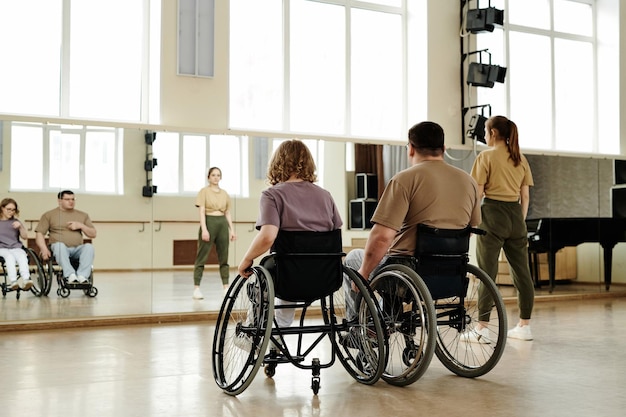 Persone che si esercitano a ballare in sedia a rotelle in classe in studio