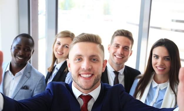 Persone che si fanno selfie durante una riunione di lavoro