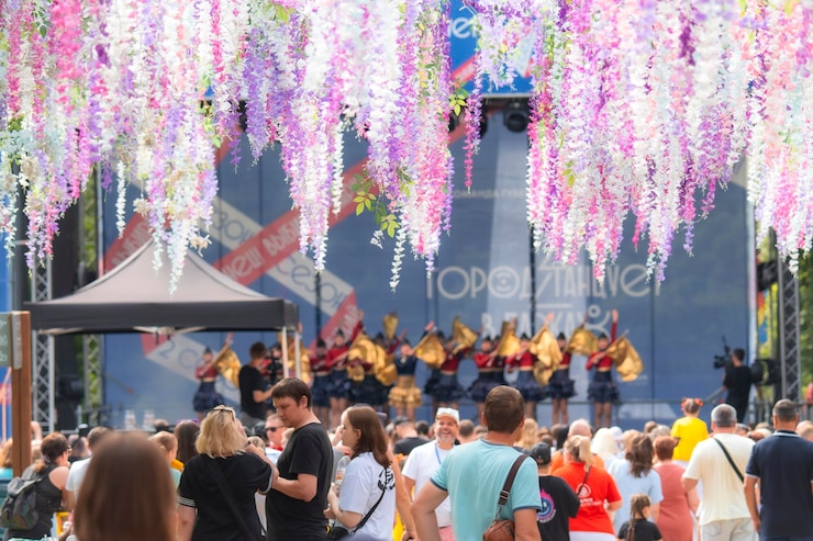 Foto persone che si godono la festa con spettacoli teatrali e decorazioni floreali