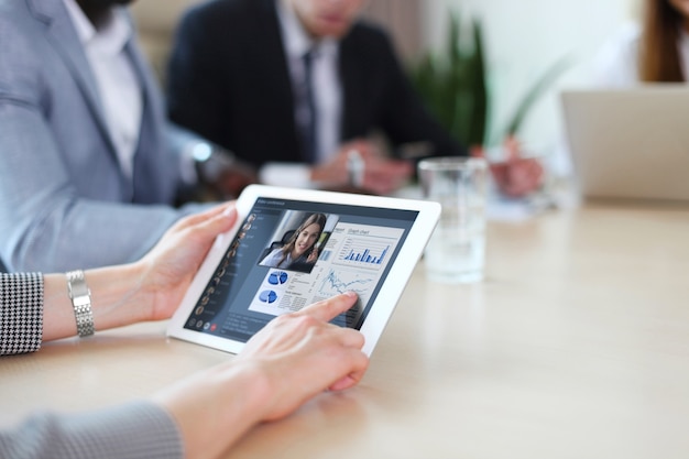 Persone che si incontrano analizzando le statistiche finanziarie in ufficio. Gruppo di team aziendali che hanno videoconferenza con il proprio team su tablet digitale, lavoro a distanza a casa.