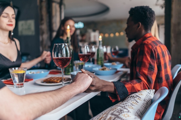 Persone che si tengono per mano pregando il concetto di celebrazione del ringraziamento.