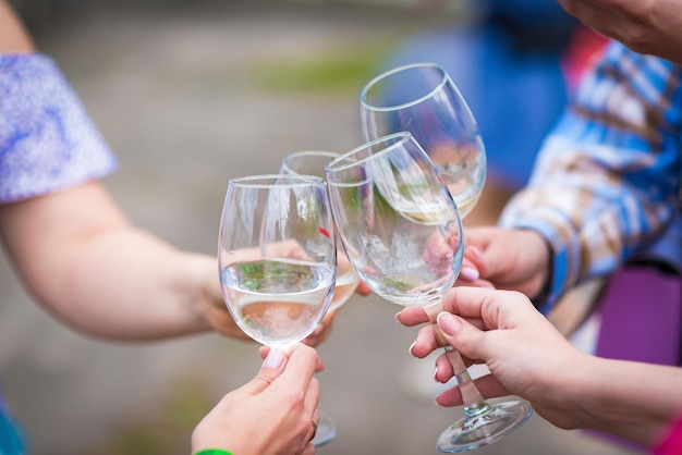 Persone che tintinnano bicchieri di vino sulla terrazza estiva del bar o del ristorante