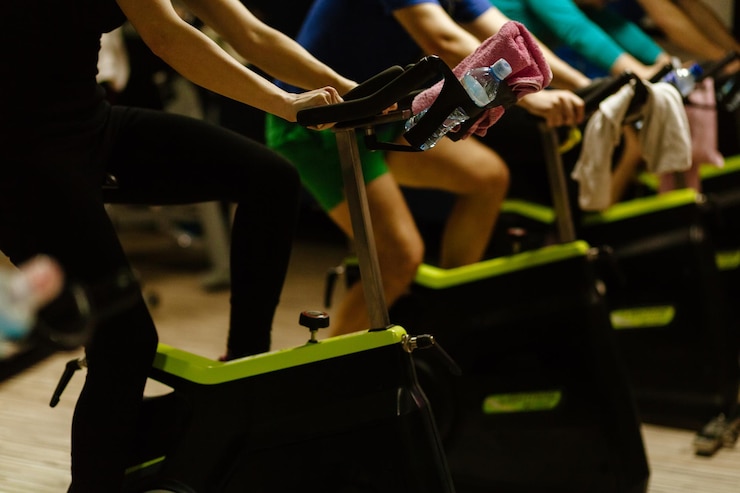 Foto persone che usano le biciclette da ginnastica in palestra
