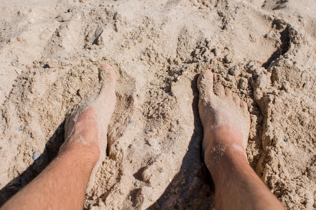 Persone con i piedi nella sabbia sulla spiaggia