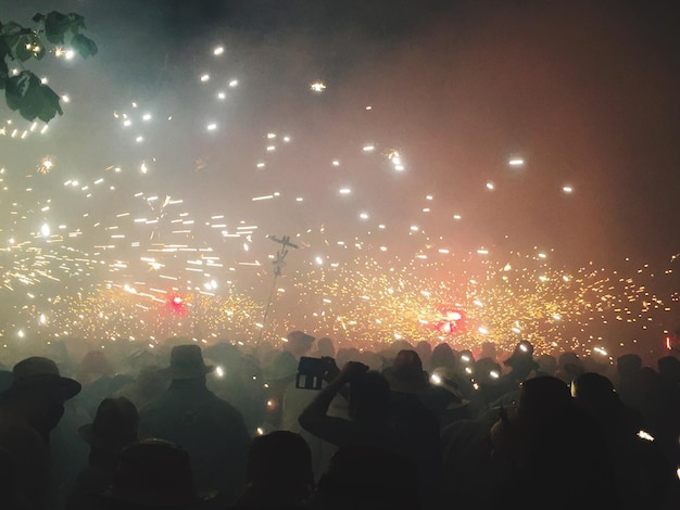 Persone contro i fuochi d'artificio illuminati durante la festa tradizionale di notte