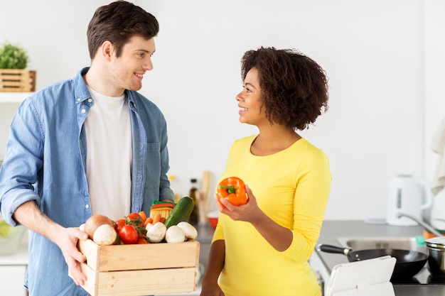 persone, cucina e concetto di alimentazione sana - coppia felice con scatola di cibo nella cucina di casa