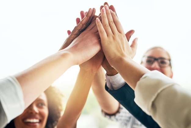 Persone d'affari e felici con il high five in ufficio per la collaborazione lavoro di squadra e unità sul progetto Dipendenti solidarietà e sorriso con sinergia o raggruppamento per il coworking con celebrazione e supporto