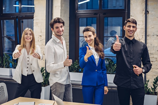 persone di affari che mostrano i pollici in su in ufficio