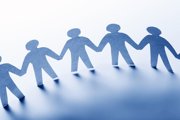 Persone di carta in piedi insieme mano nella mano Concept di business della società di squadra