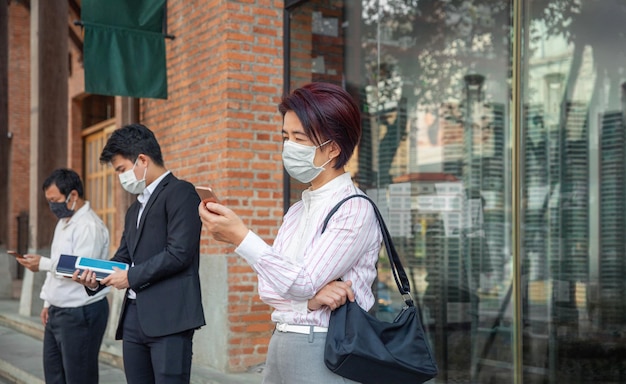 Persone di mezza età asiatiche che indossano la maschera e mantengono le distanze sociali per evitare la diffusione del COVID19