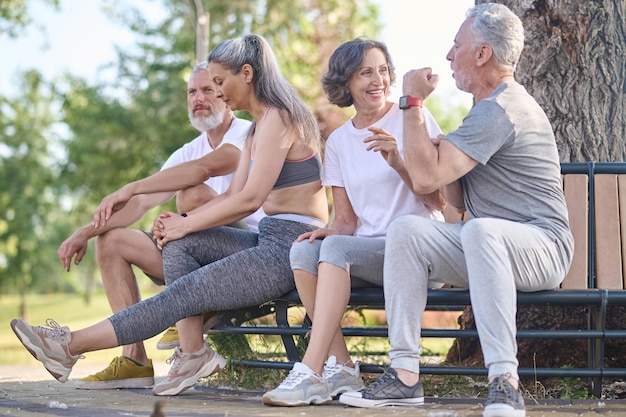 Persone di mezza età che riposano nel parco dopo l'allenamento