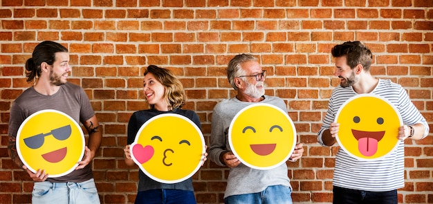 Persone felici tenendo emoticon positivo