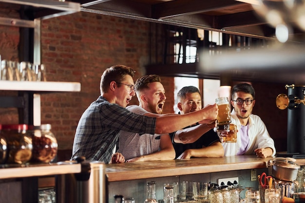 Persone in abiti casual seduti al pub e a bere birra