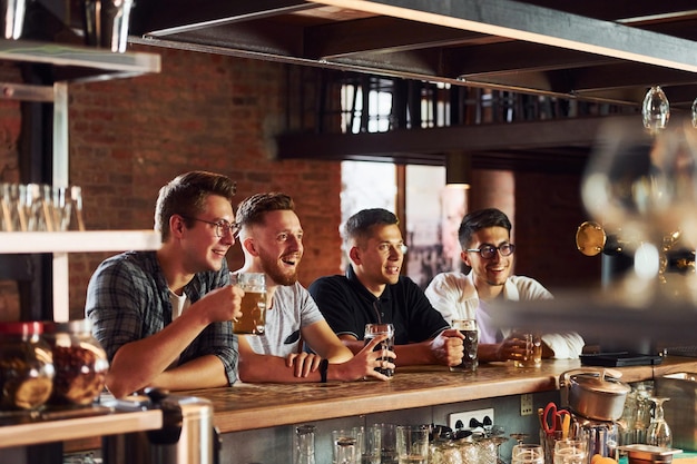 Persone in abiti casual seduti al pub e a bere birra