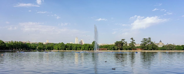 Persone in barche a remi sul lago della casa di campagna di Madrid in una giornata estiva e con vista sui famosi edifici della città, inclusa la sua cattedrale