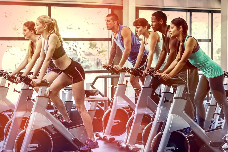 Foto persone in forma che si allenano alla lezione di spinning