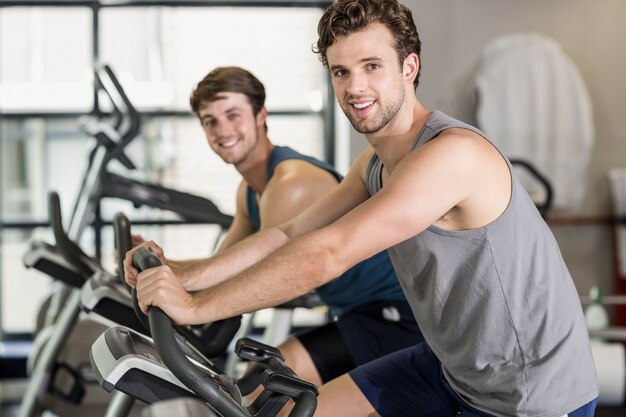 Persone in forma facendo cyclette in palestra