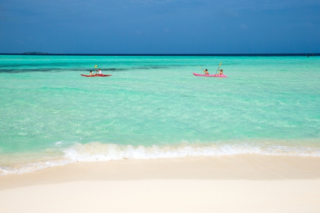 Persone in kayak. Mare tropicale sotto il cielo blu