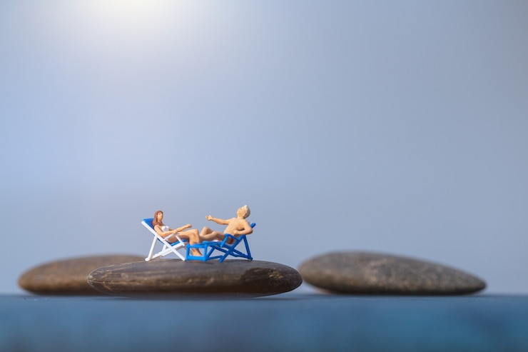 Foto persone in miniatura a prendere il sole sulla spiaggia, concetto di ora legale