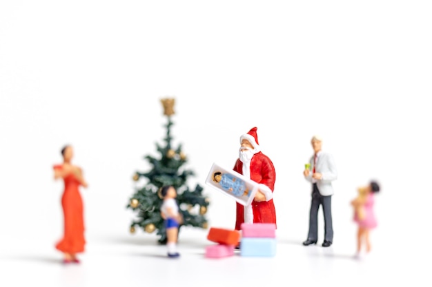 Persone in miniatura: Babbo Natale in possesso di regalo per la famiglia felice, Natale e felice anno nuovo concetto.