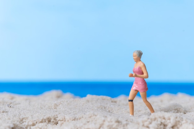 Persone in miniatura che corrono sulla spiaggia