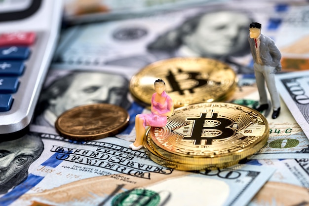 Persone in miniatura con bitcoin e dollari