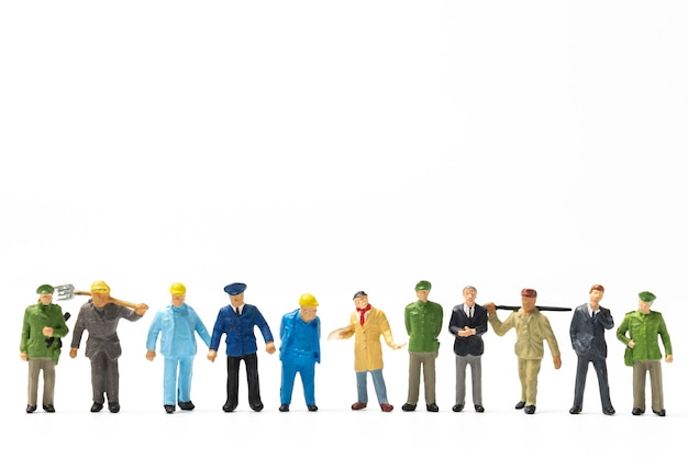 Persone in miniatura diverse professioni in piedi su sfondo bianco Concetto di festa del lavoro