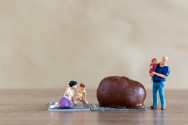 Persone in miniatura Famiglia felice godendo di cioccolato
