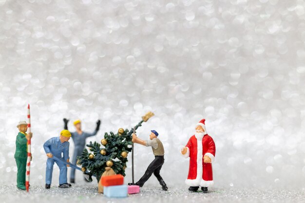 Persone in miniatura: il gruppo di lavoro prepara l'albero di Natale