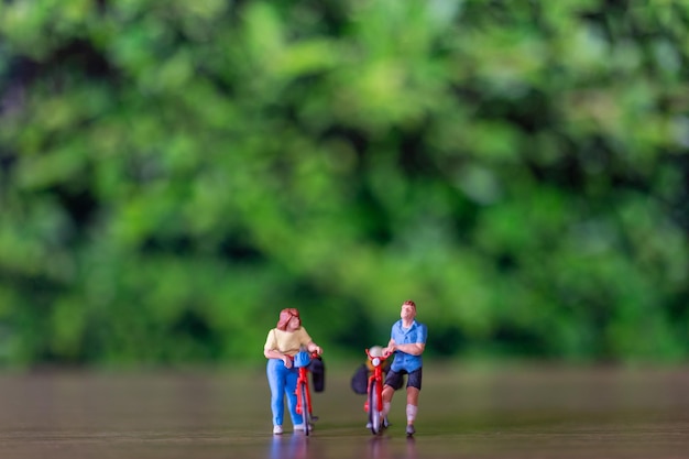 Persone in miniatura in piedi con la bici Giornata mondiale della bicicletta concetto